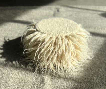 A round shaggy pouf made of wool -0