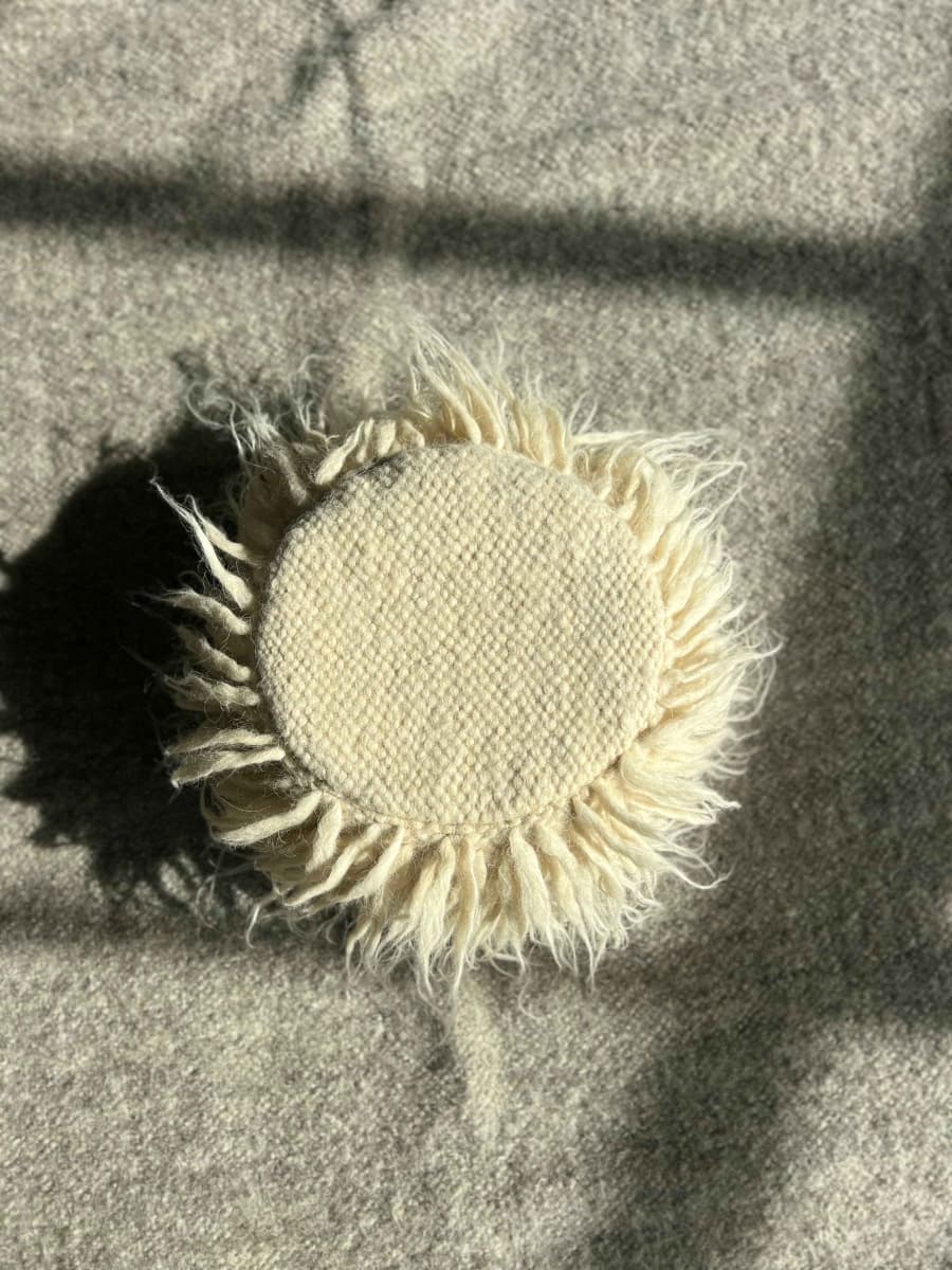 A round shaggy pouf made of wool -1